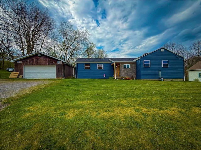 ranch-style home with a detached garage, an outdoor structure, and a front yard