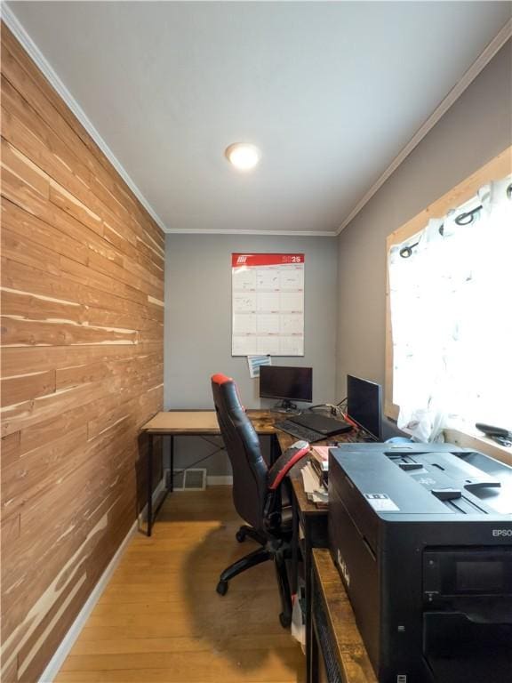 office area featuring wooden walls, baseboards, ornamental molding, and wood finished floors