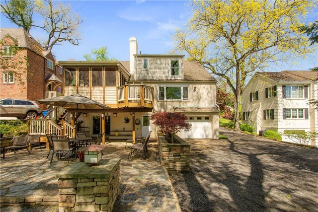 1427 Pueblo Dr, Mt Lebanon, PA 15228 - rear view of property with a sunroom, a chimney, stairway, an attached garage, and asphalt driveway