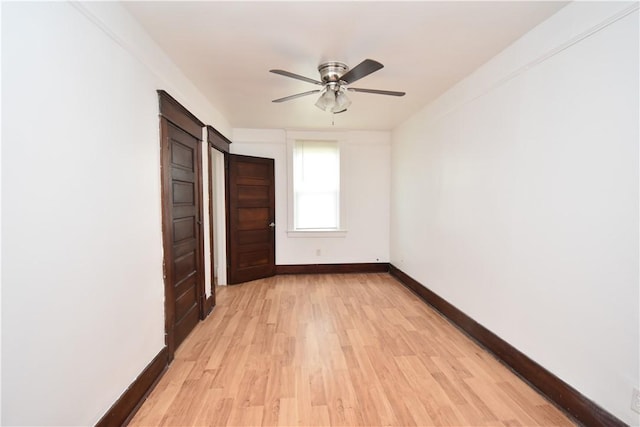 unfurnished bedroom featuring baseboards, ceiling fan, and light wood-style flooring