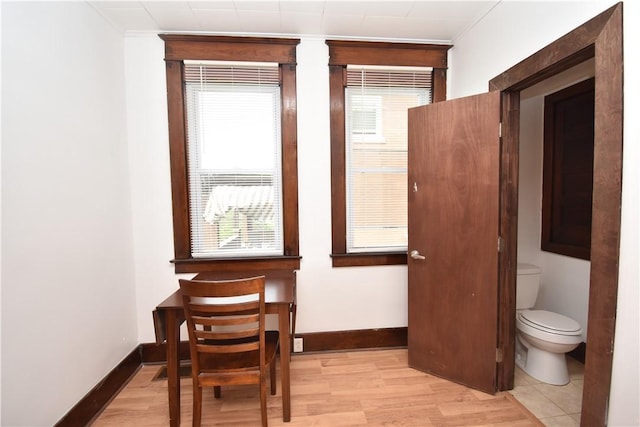 interior space featuring baseboards, crown molding, wood finished floors, and toilet