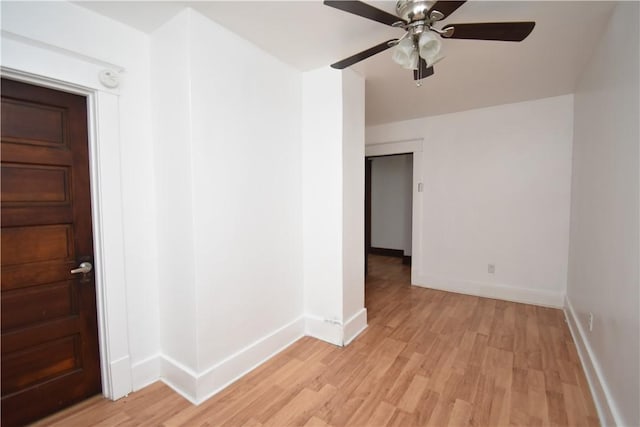 spare room with baseboards and light wood-type flooring