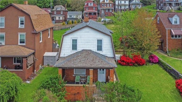 view of front facade featuring brick siding, a residential view, and a front lawn