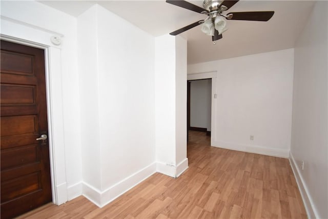 unfurnished room with baseboards, a ceiling fan, and light wood finished floors