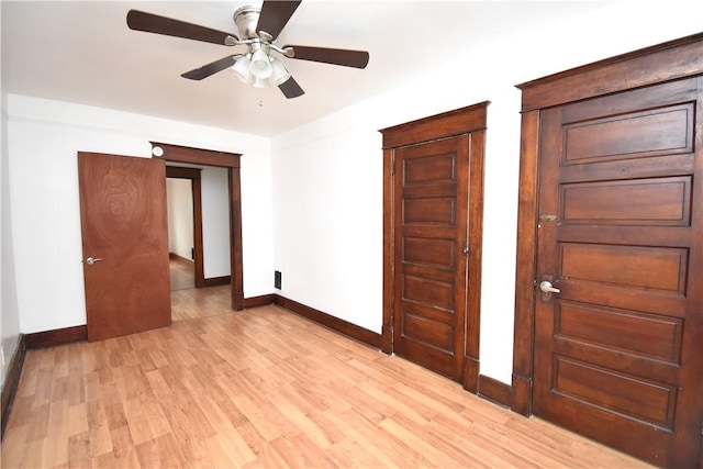empty room featuring light wood-style floors, baseboards, and a ceiling fan