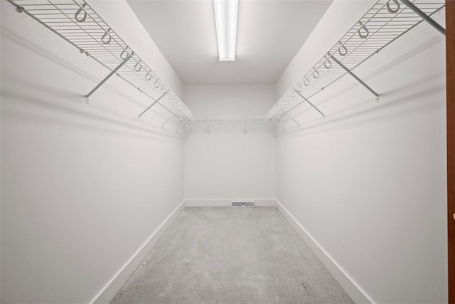 walk in closet featuring visible vents and light colored carpet