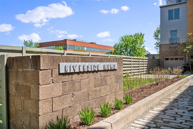 community / neighborhood sign with fence
