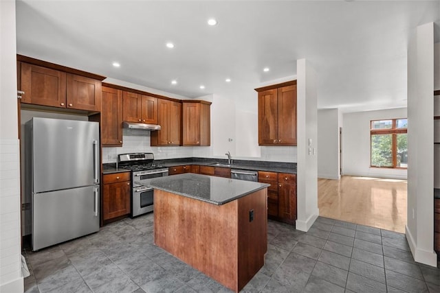 kitchen featuring a center island, a sink, tile patterned floors, under cabinet range hood, and stainless steel appliances