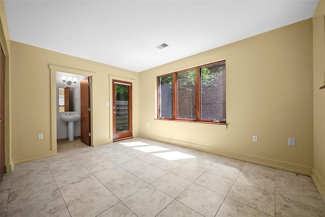 unfurnished bedroom with light tile patterned flooring, baseboards, and access to exterior
