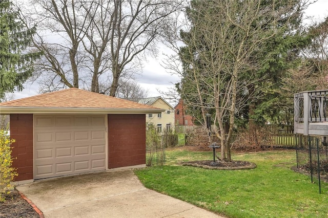 detached garage with fence and concrete driveway