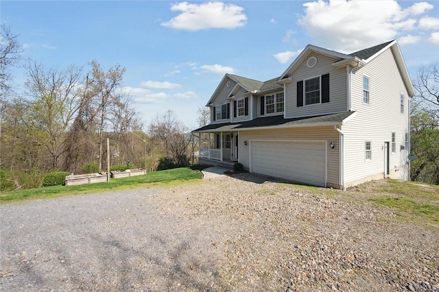 traditional-style house with a porch, a garage, and dirt driveway
