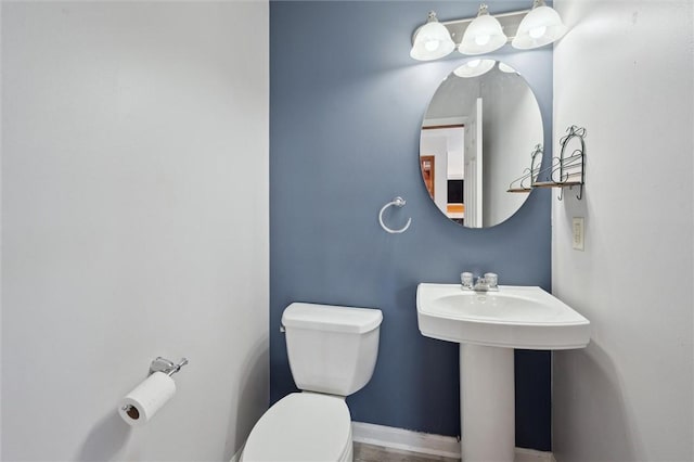 half bath featuring a sink and toilet