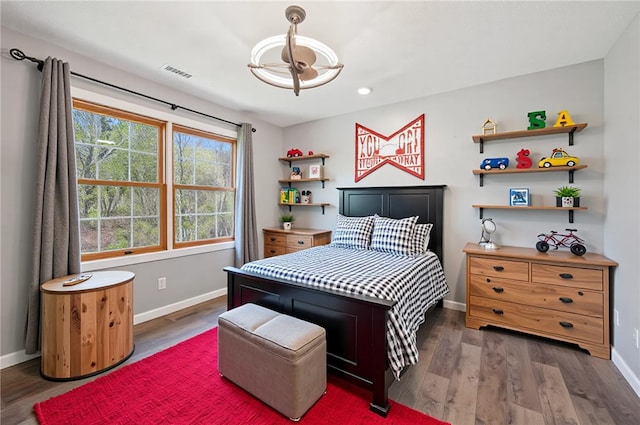 bedroom featuring visible vents, baseboards, and wood finished floors