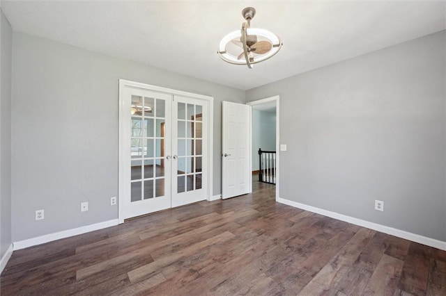 unfurnished dining area featuring baseboards, a chandelier, french doors, and wood finished floors
