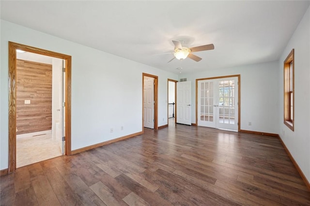 empty room featuring french doors, dark wood-style flooring, ceiling fan, and baseboards