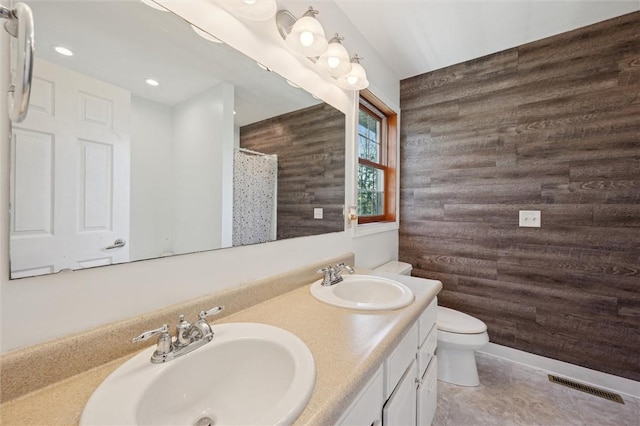 full bath featuring visible vents, a sink, wooden walls, and toilet