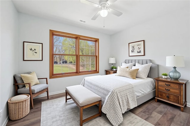 bedroom with baseboards, ceiling fan, wood finished floors, and visible vents