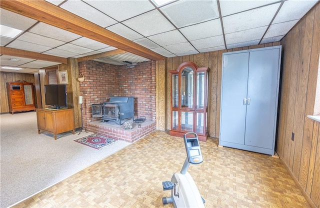 500 11th St, Oakmont, PA 15139 - interior space with wood walls, a paneled ceiling, a wood stove, and light floors