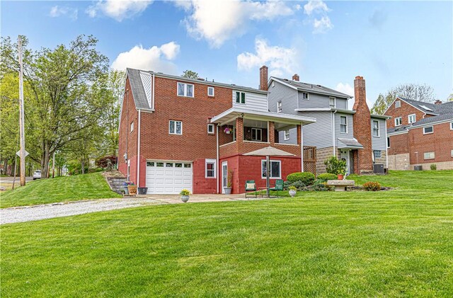 500 11th St, Oakmont, PA 15139 - back of house featuring a lawn, brick siding, an attached garage, and driveway