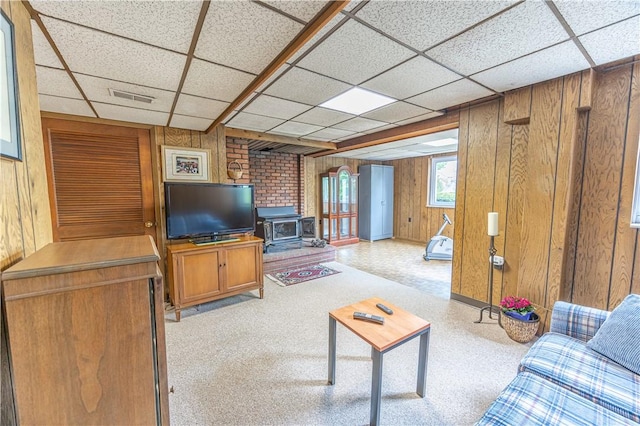 500 11th St, Oakmont, PA 15139 - living area featuring visible vents, a wood stove, a drop ceiling, and wooden walls