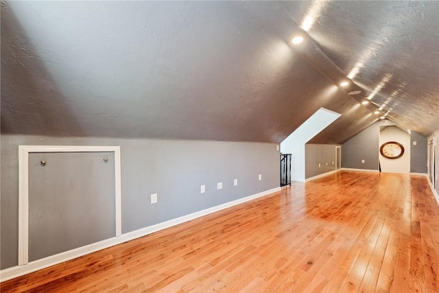 bonus room featuring baseboards, wood-type flooring, and lofted ceiling