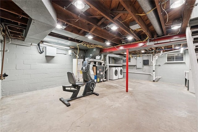 unfinished basement with electric panel, gas water heater, washing machine and clothes dryer, concrete block wall, and heating unit