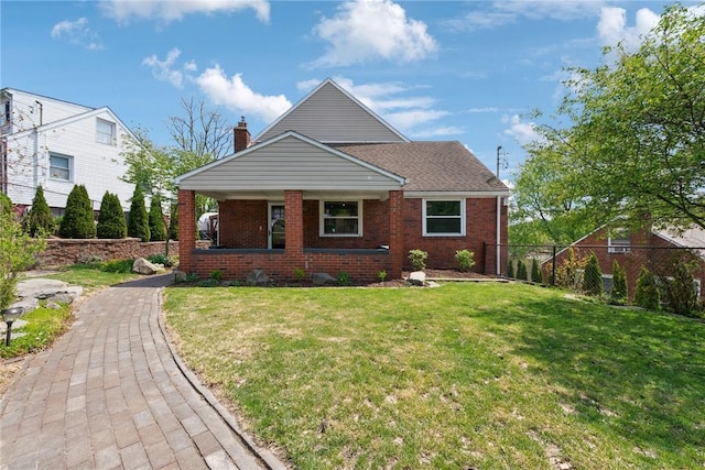 bungalow-style house featuring fence, covered porch, a front yard, and brick siding