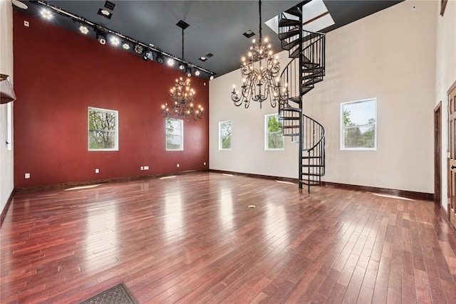 interior space with track lighting, a chandelier, stairway, and hardwood / wood-style flooring