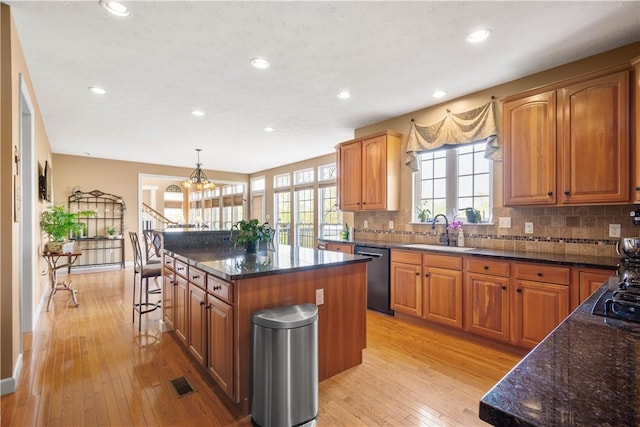 342 Buffalo Ridge Rd, Peters Twp, PA 15317 - kitchen with light wood-style floors, dishwashing machine, a center island, a sink, and backsplash