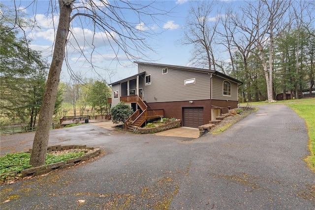 209 Claypoole Hill Rd, Bethel Twp, PA 16226 - view of property exterior featuring an attached garage, a sunroom, stairway, and aphalt driveway