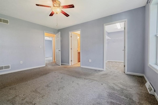 unfurnished bedroom featuring visible vents, carpet flooring, and a spacious closet