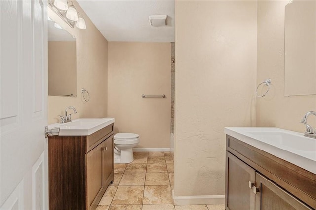full bath featuring a sink, baseboards, toilet, and two vanities