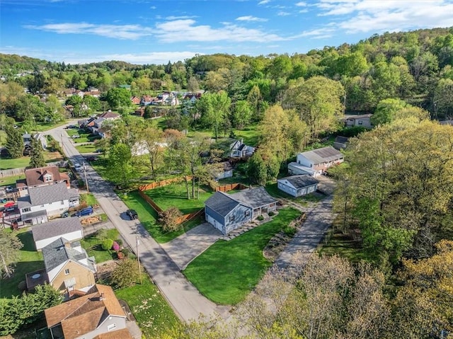 drone / aerial view featuring a wooded view and a residential view
