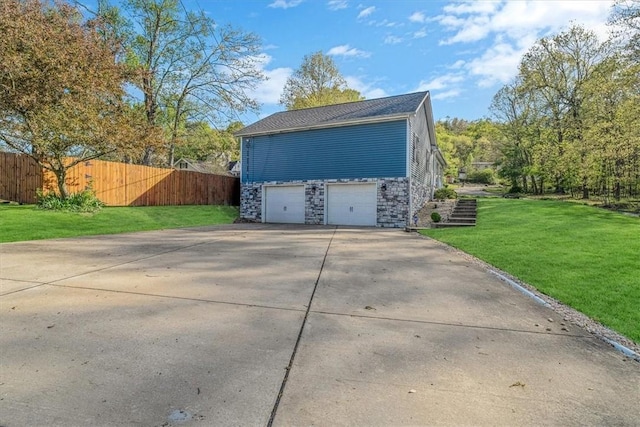 garage with fence and concrete driveway