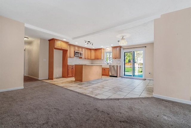 kitchen with light colored carpet, recessed lighting, light countertops, a center island, and appliances with stainless steel finishes