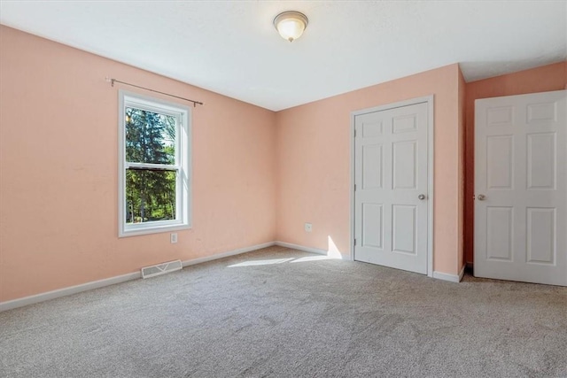 unfurnished bedroom with baseboards, visible vents, and carpet