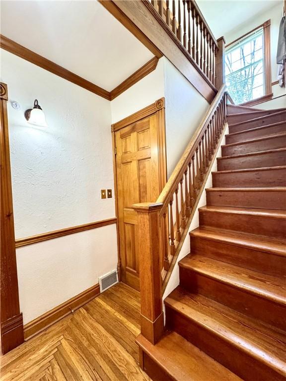 1214 Chislett St, Morningside, PA 15206 - staircase featuring crown molding, baseboards, wood finished floors, and visible vents