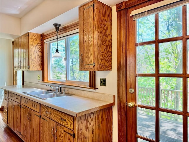 1214 Chislett St, Morningside, PA 15206 - kitchen featuring light countertops, brown cabinets, decorative light fixtures, and a sink