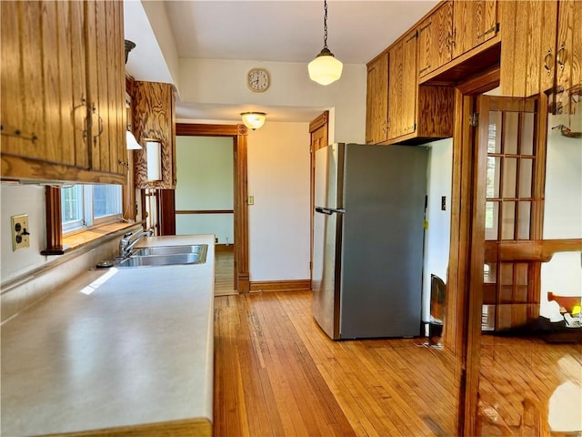 1214 Chislett St, Morningside, PA 15206 - kitchen featuring freestanding refrigerator, light wood-type flooring, light countertops, brown cabinets, and a sink