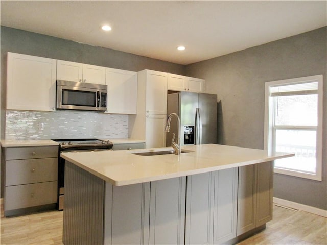 776 W Vine St, Mount Pleasant Boro, PA 15666 - kitchen with appliances with stainless steel finishes, a sink, light wood-style floors, light countertops, and backsplash