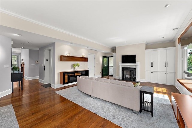 living room with visible vents, ornamental molding, a fireplace, baseboards, and dark wood-type flooring