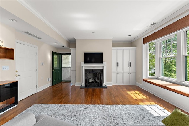 unfurnished living room with a healthy amount of sunlight, a fireplace with raised hearth, wood finished floors, and visible vents