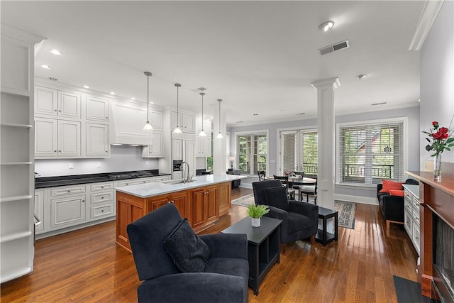 living room featuring crown molding, recessed lighting, ornate columns, visible vents, and dark wood-style floors