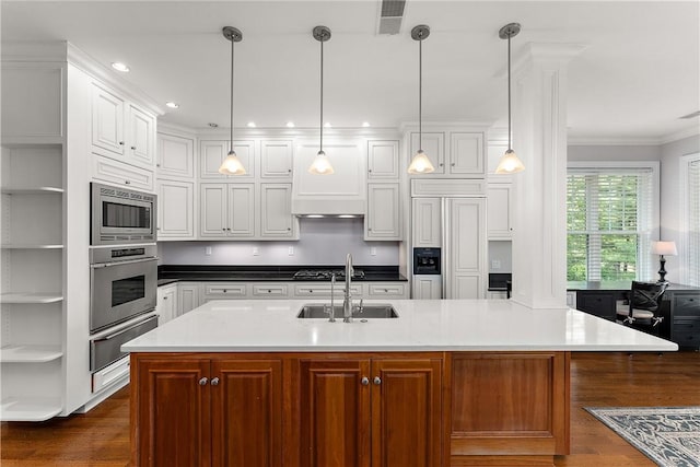 kitchen featuring open shelves, built in appliances, a sink, dark wood finished floors, and a warming drawer