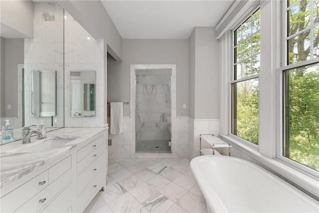 full bathroom featuring a freestanding bath, a shower stall, marble finish floor, and vanity
