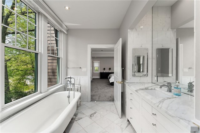 full bathroom featuring vanity, a soaking tub, recessed lighting, and marble finish floor