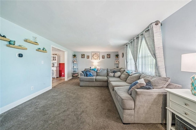 carpeted living area featuring baseboards