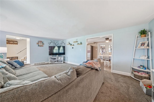 living area with visible vents, stairs, carpet floors, and baseboards