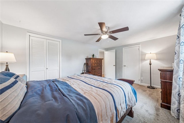 bedroom featuring baseboards, a ceiling fan, a closet, and light colored carpet