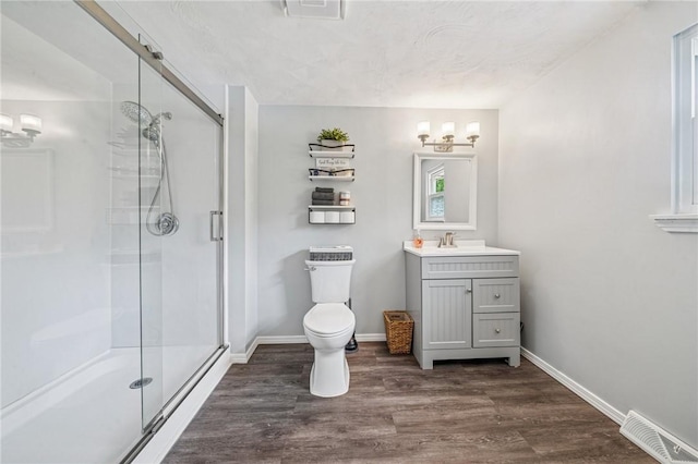 bathroom featuring vanity, a stall shower, wood finished floors, and visible vents
